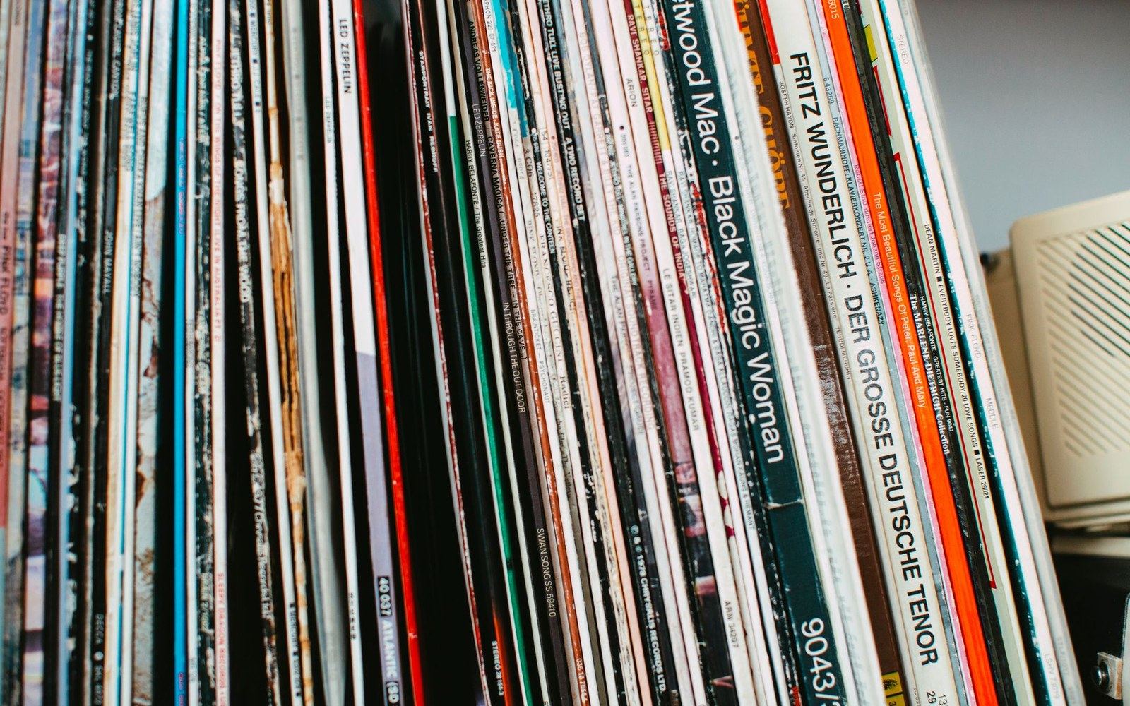 Rows of vinyl record albums standing upright on a shelf, spines facing forward
